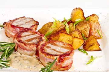 Grilled steak wrapped in bacon, with grilled vegetables