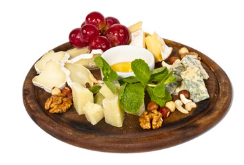 Various types of cheese with honey, nuts and grapes on plate, is