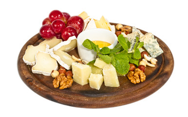 Various types of cheese with honey, nuts and grapes on plate, is