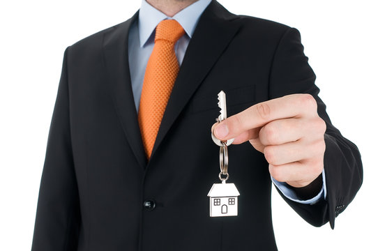 man with black suit holding a key