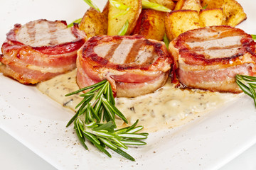 Grilled steak wrapped in bacon, with grilled vegetables