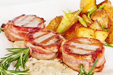 Grilled steak wrapped in bacon, with grilled vegetables