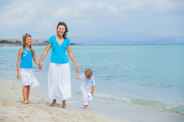 Mother and two kids having fun on beach