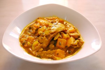 Stew seitan with yellow peppers and spices in white plate