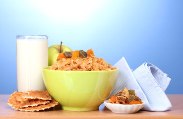 tasty cornflakes in green bowl, apples and glass of milk