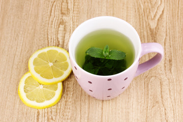 Mint tea with mint leaf and lemon on wooden background