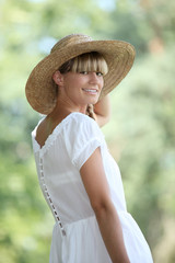 woman wearing a straw hat walking in the nature