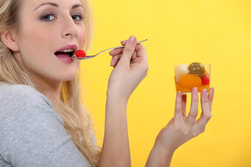 Woman eating fruit cocktail