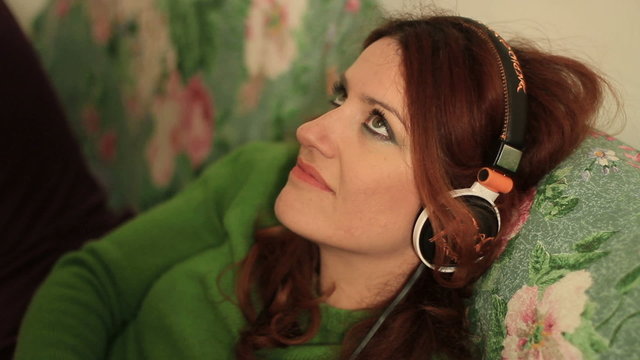 Redheaded woman uses an mp3 player