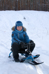 Fototapeta na wymiar Cheerful boy walks in winter park