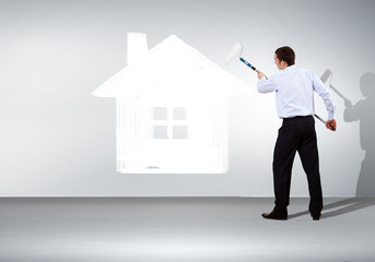 Businessman and picture of house on the wall