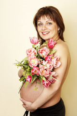 Pregnant woman holding a bunch of flowers