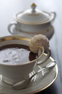 Cioccolata in tazza con canestrello sul bordo e zuccheriera