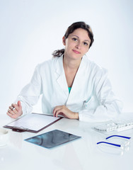 portrait of confident female doctor sitting on her desk