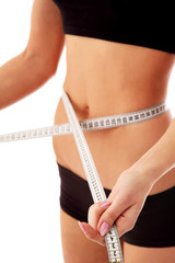 Woman measure her waist belly by metre-stick.