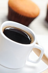 Coffee and cake in the background.