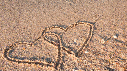 2 verschlungene Herzen am Strand