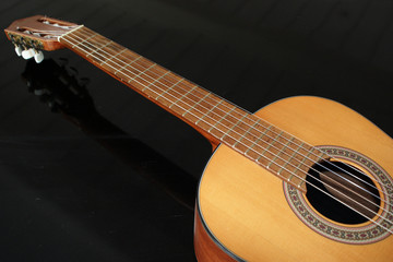Fototapeta na wymiar Classic wooden guitar on black background