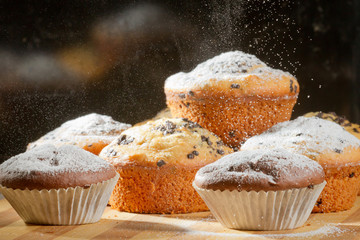 Sprinkling caster sugar on some muffins
