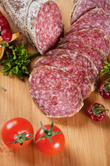 Sliced salami with chili peppers and herbs