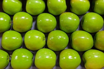 Granny Smith Apples in a fruit packing warehouse - lined up on a packing tray