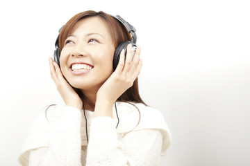 Fototapeta premium ヘッドホンで音楽を聞く女性