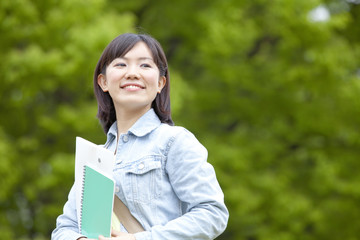 Fototapeta premium 新緑の下で微笑む大学生