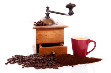 Old wooden coffee grinder with beans and cup