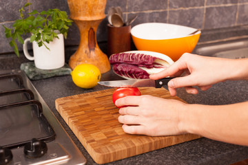 Woman Cutting Tomato in the Kitchen
