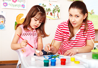 Child painting with mother  in preschooler.