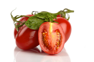 Frische Roma Tomaten mit Basilikum vor weißem Hintergrund