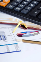 Obraz premium The diagramme with the calculator and a pencil