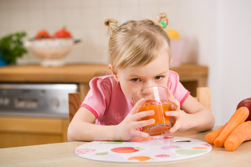 Obraz na płótnie Canvas little girl with carrot juice