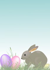 Osterhase sitzt im Gras mit Ostereiern