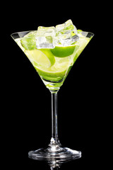 glass of cocktail with lime and mint on black background