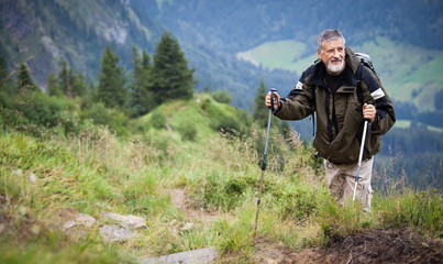 Fototapeta na wymiar Active senior hiking in high mountains (Swiss Alps)