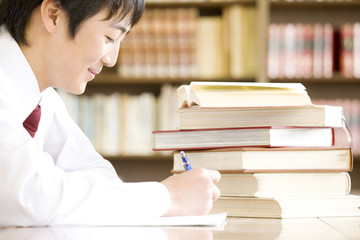 図書室で勉強する男子中学生