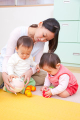 Obraz na płótnie Canvas おもちゃで遊ぶ乳児2人と保育士