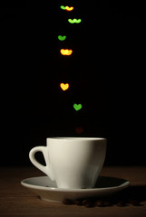 cup of coffee on wooden table on bright bokeh backdground