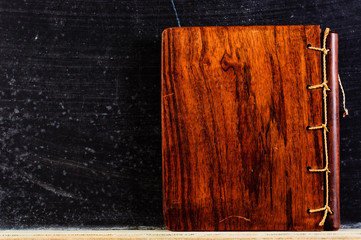Wooden Book against black chalkboard