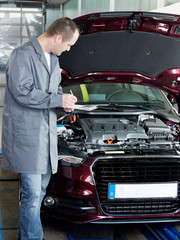 Master mechanic in garage checking engine bay for an offer