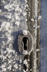 Frozen keyhole at wooden door