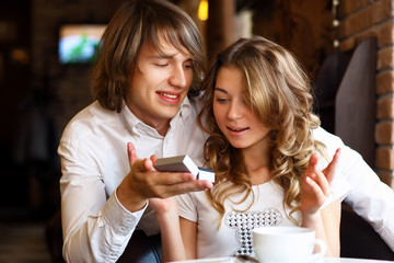 Young couple with engagement ring in a restaurant