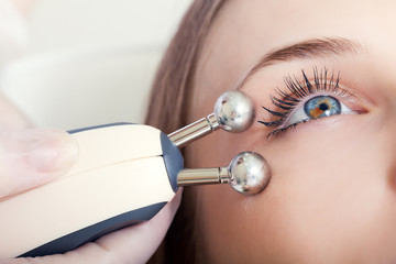 woman having a stimulating facial treatment from a therapist