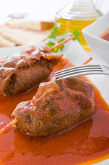 Meat roulade on white dish.