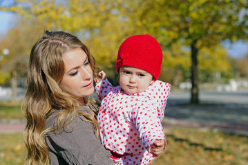 The young beautiful girl with the small child in autumn park