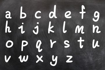 English alphabet handwritten with white chalk on a blackboard