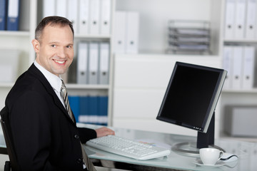 zufriedener geschäftsmann arbeitet am schreibtisch