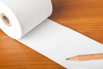 Roll of paper and pencil on a table top