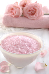 Obraz na płótnie Canvas Bowl of bath salt with pink rose on towel